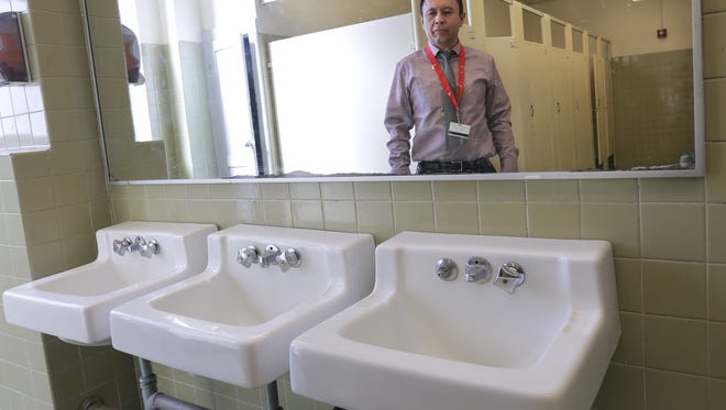 Jefferson High School Principal Fred Rojas is reflected in the mirror of one of the school’s girl’s bathrooms. 