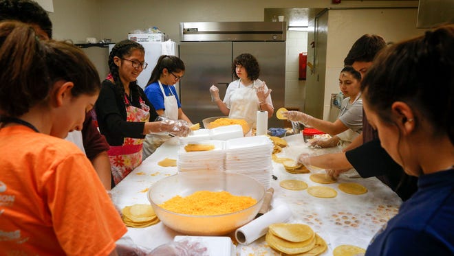 St. Mary's Youth Group members assemble enchiladas on Feb. 13, 2018, during the annual Cheese Enchilada Take-Out sale at St. Mary's Parish Center in Farmington.