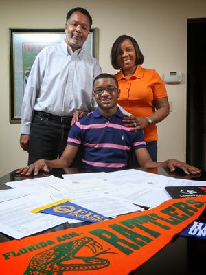 Brown School senior Emmanuel Blake Dawson poses with his parents Greg Dawson, left, and Opal Dawson.  Blake has amassed about $1 million in scholarship offers to college.  He has decided to go to Florida A & M.
April 8, 2016