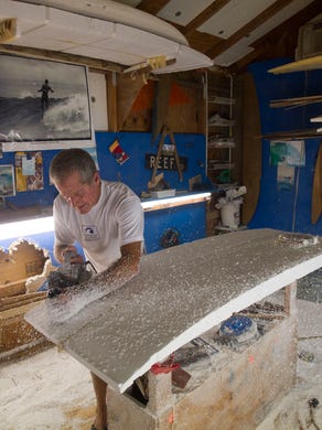 Charles Williams, maker of Impact surfboards, shapes a foam board with a Skil 100 planer from his shop Oct. 17 in Fort Pierce. "It's all about the shape. You can train monkeys to glass these things and sand them and everything, but the shape, it's all about the shape. That's what counts, that's what rides, that's what makes the boards," Williams said. He mostly works alone and doesn't really advertise, saying marketing is done at the beach when he and others, including twin brother George Williams, use Impact surfboards. "I'm a surfer, not a businessman." 