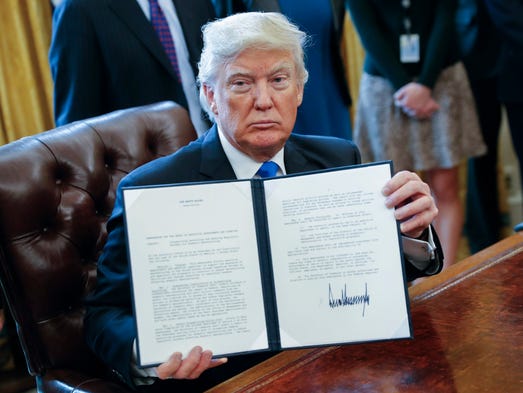 Trump displays one of five executive actions he signed