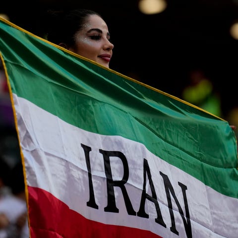 A soccer fan holds a flag from Iran prior to the W