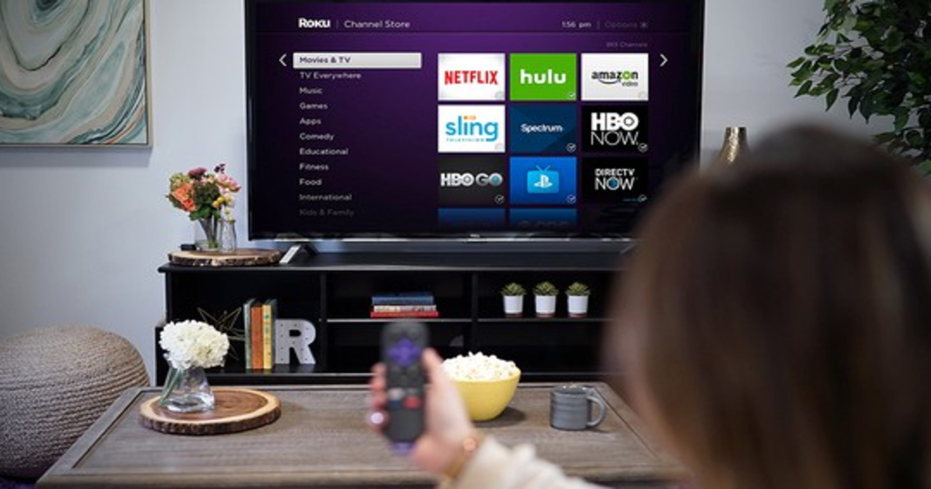 リビング ルームのメディア キャビネットにある Samsung TU69OT 4K スマート テレビ。