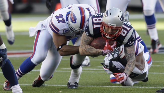 New England Patriots tight end Aaron Hernandez (81) dives ahead for a gain against Buffalo Bills strong safety George Wilson (37) during the second quarter of an NFL football game in Foxborough, Mass., Sunday Jan. 1, 2012.