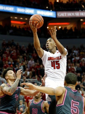 Louisville's Donovan Mitchell goes over several Virginia Tech defenders on his way to scoring 26 points. Feb. 18, 2017