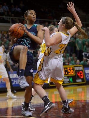 Saginaw Heritage Shine Strickland-Gills drives the basket against Grosse Pointe North's Josephine Ciaravino during the second half Friday in a Class A semifinal at Calvin College.