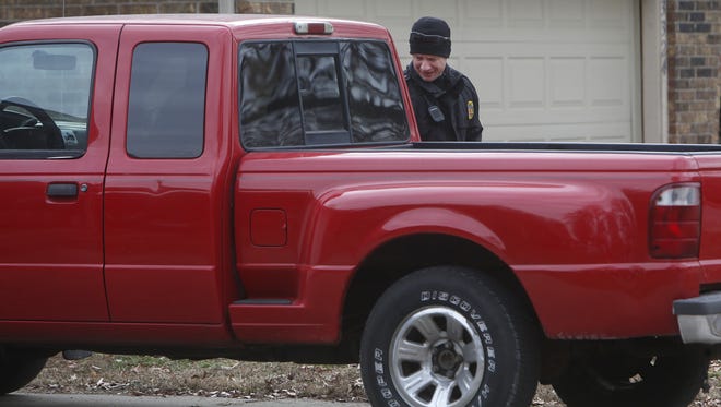 A Springfield police officer looks into a truck in south Springfield in December.