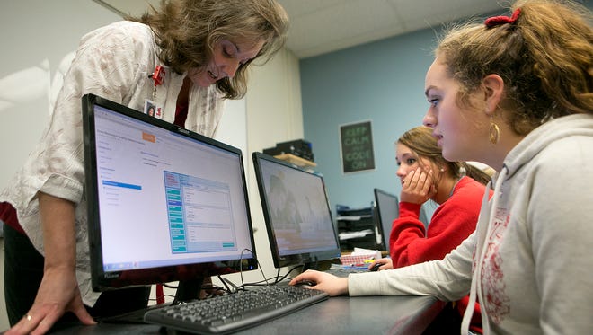Teacher Kathy Jarosinski, left, helps seniors Ana Tapia, right, and Emily Westover, center,  during medical terminology class at Lincoln High School in Wisconsin Rapids, Monday, Dec. 14, 2015. This school year, Lincoln High School switched to a trimester schedule.