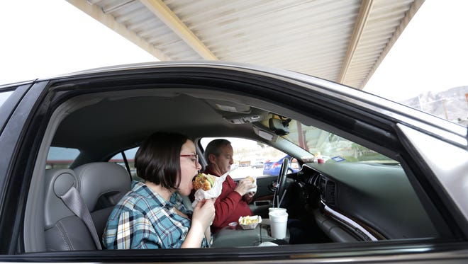 Madison and Kevin Alford eat  their burgers Friday from the Charcoaler Drive-In hamburger restaurant in West El Paso. The iconic drive-in has been swamped since owner Bob Cox Jr., announced earlier this week he's closing the 55-year-old business Jan. 31.