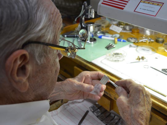 Ralph Hutchinson places the face of a watch he recently