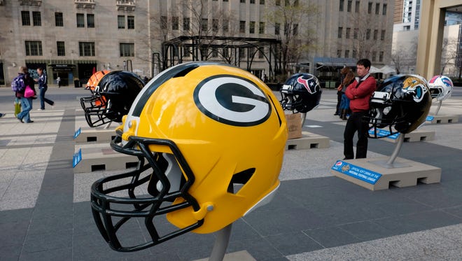 Giant NFL football helmets are displayed in Pioneer Court in downtown Chicago, as the city prepares to host the 2015 NFL Draft from April 30 to May 2.