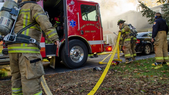 Fire fighters work on a blaze Sunday, Nov. 6, on Waldheim Drive in Port Huron Township.