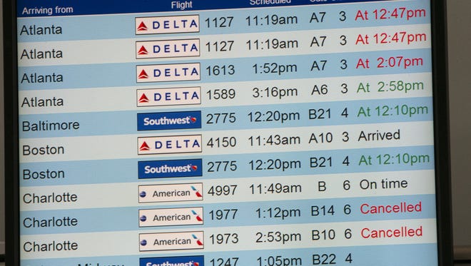 An arrival board shows some canceled flights at Indianapolis International Airport, Friday, Jan. 22, 2016. A large East Coast blizzard is expected to snarl air travel into the weekend.