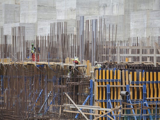 Workers stand on scaffolding during the construction