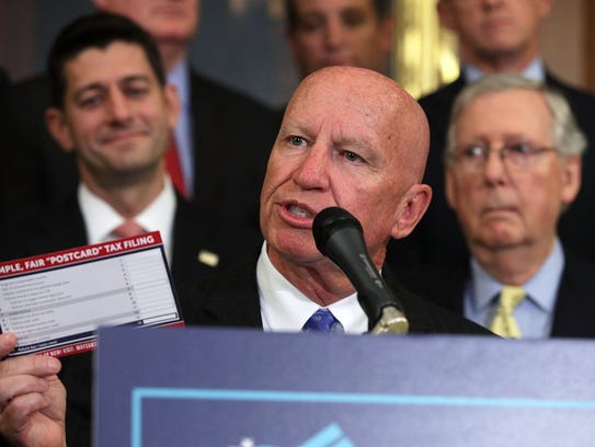 Rep. Kevin Brady holds up a tax filing postcard during