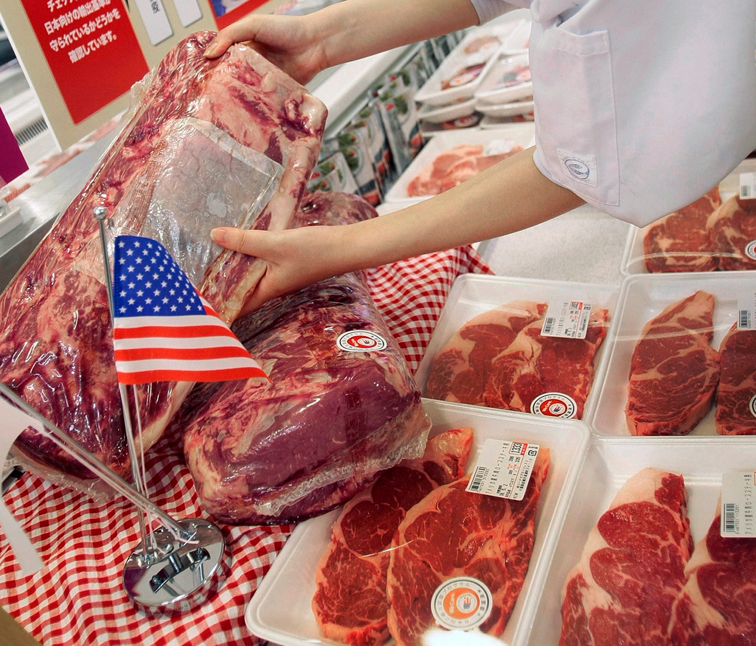 A sales person at Jusco Supermarket arranges U.S. Beef products in Tokyo. Japan is slapping emergency tariffs of 50% on imports of frozen U.S. beef after shipments surged. Finance Minister Taro Aso announced the move Friday,  July 28, 2017, saying he