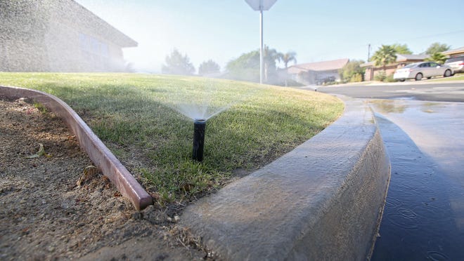 A misaligned sprinkler sends water into a gutter in La Quinta in 2015.