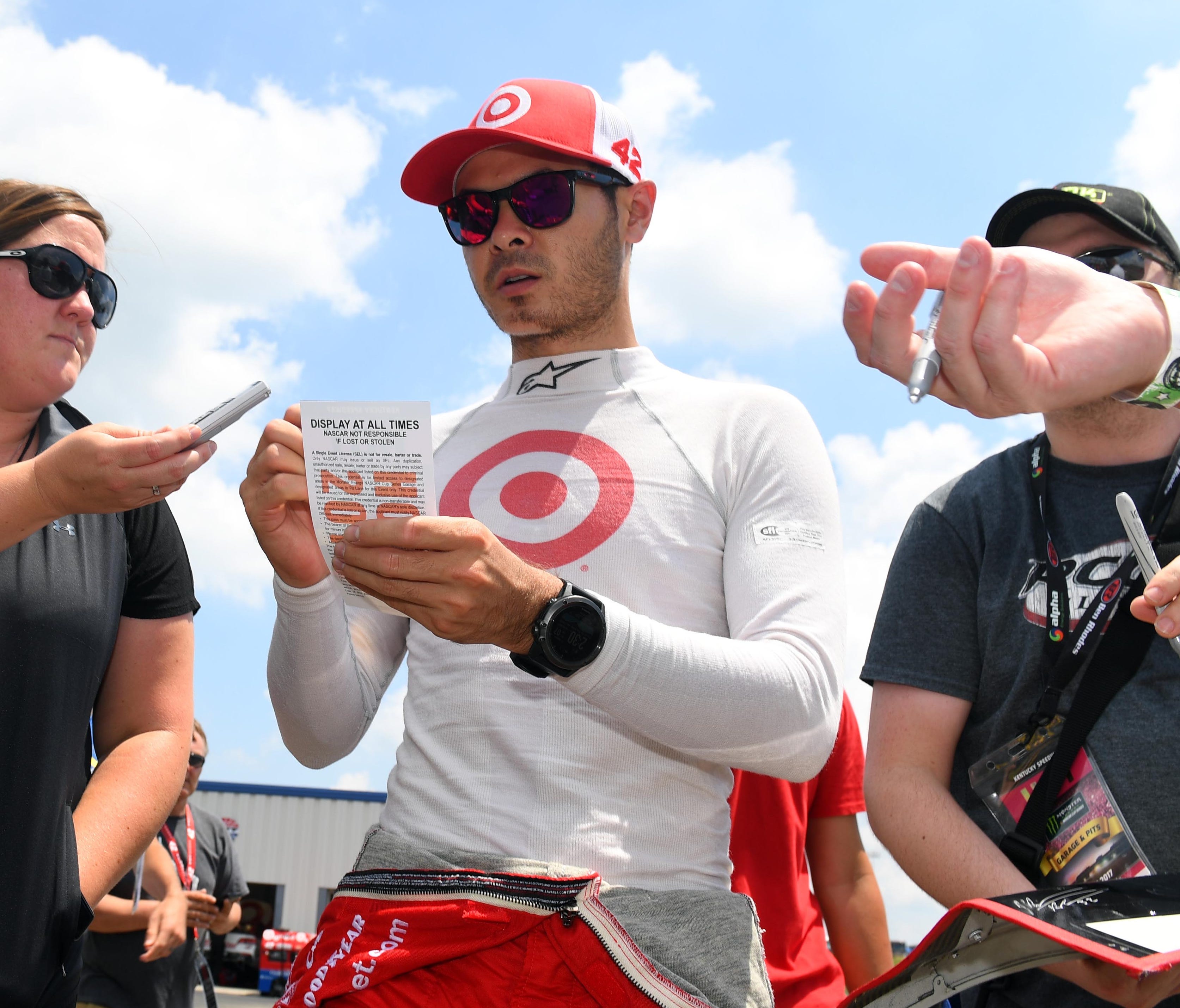 Driver Kyle Larson signs autographs for fans following practice for the Quaker State 400 at Kentucky Speedway.