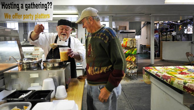 Ed Mull pours soup for Paul Fowler of Abbottstown at Mull's stand, Judy Mae's Old Fashioned Treats, at Penn Market in 2014.
