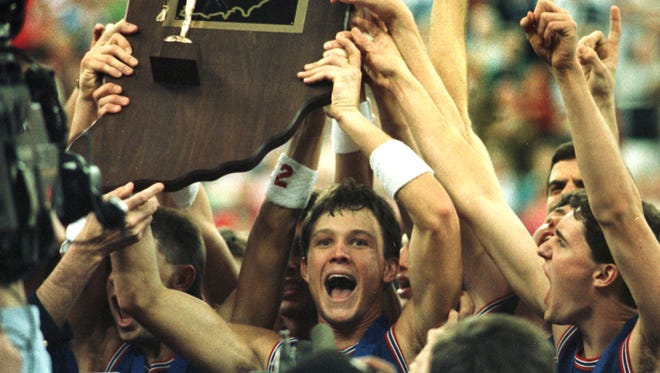 March 1990, Damon Bailey holds up the boys basketball championship trophy after leading his team, Bedford North Lawrence, to a state finals victory at the Hoosier Dome.
