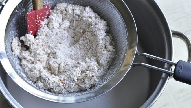 Soaked and pulverized almonds are strained to extract the almond milk.