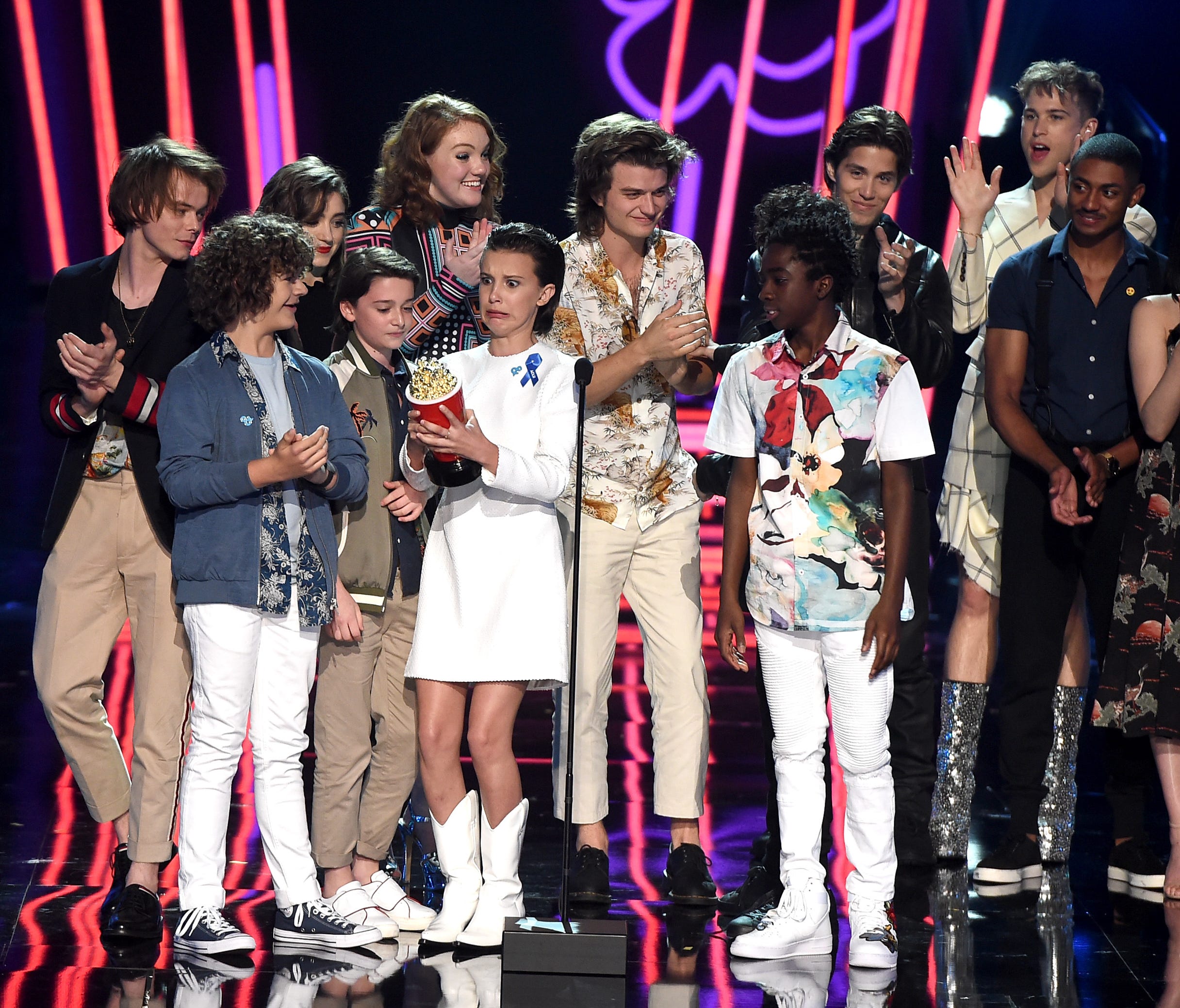 The cast of 'Stranger Things' win for Best Show, accepting the golden popcorn from the cast of '13 Reasons Why.'