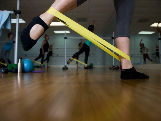 Clients participate in the barre motion class at Beyond