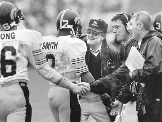 Iowa coach Hayden Fry, wearing hat, and assistant coach