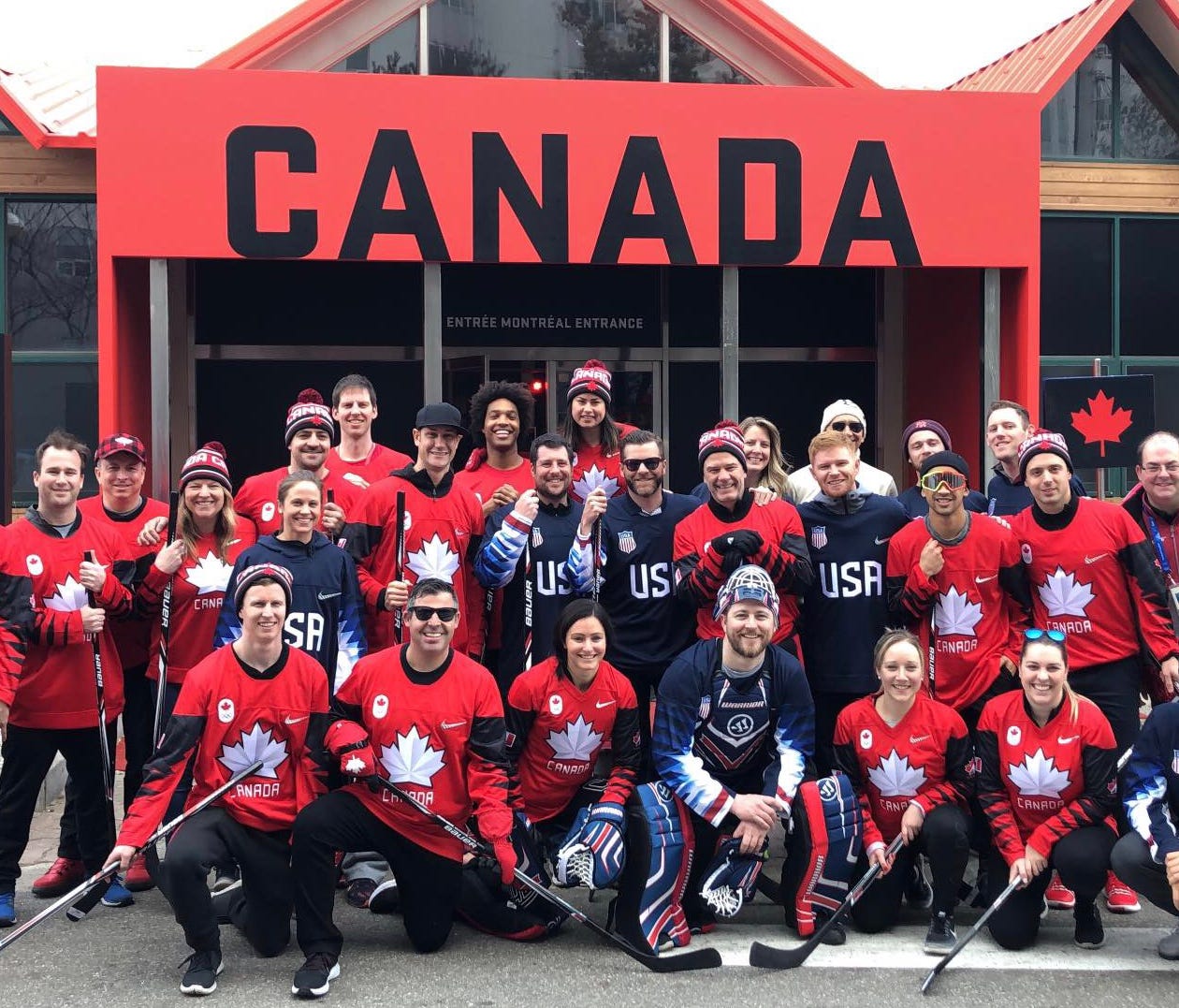 Athletes and officials from the Canadian and U.S. Olympic teams commemorate their ball hockey showdown on Friday at the Winter Olympics.