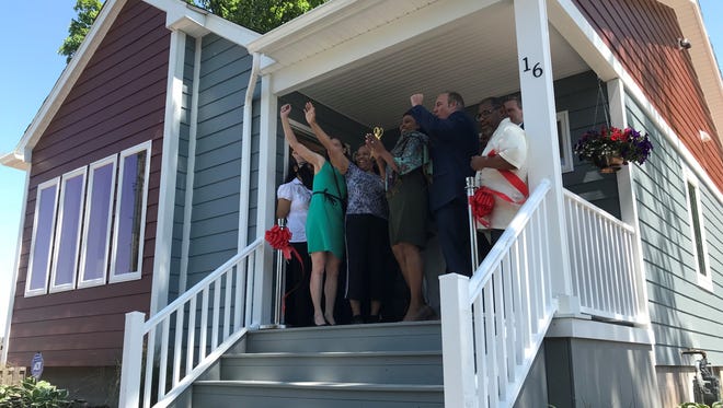 FIrst-time homeowner Loretta Cross, 65, cuts a ribbon on her new home on Diamond Place with Mayor Lovely Warren and others on Friday, May, 25, 2018.