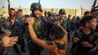 Members of the Iraqi federal police dance with children