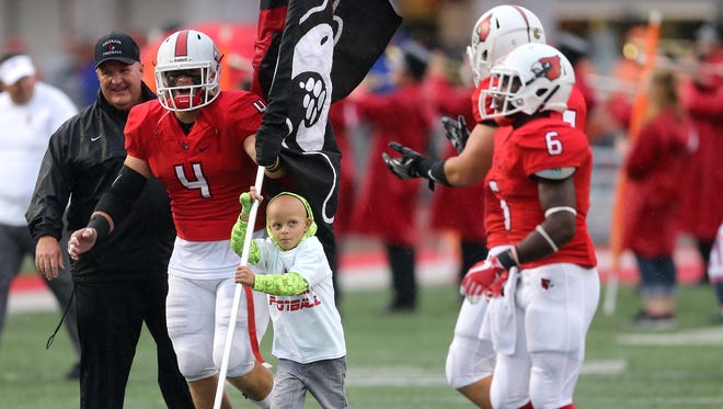 Walter Herbert, 6, leads the Colerain Cardinals on the field before the high football game between the St. Xavier Bombers and the Colerain Cardinals, Friday, Sept. 1, 2017, at Colerain High School in Colerain Township.