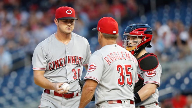 Cincinnati Reds starting pitcher Tyler Mahle (30) is removed from he game by Reds interim manager Jim Riggleman (35) against the w/ in the second inning at Nationals Park.