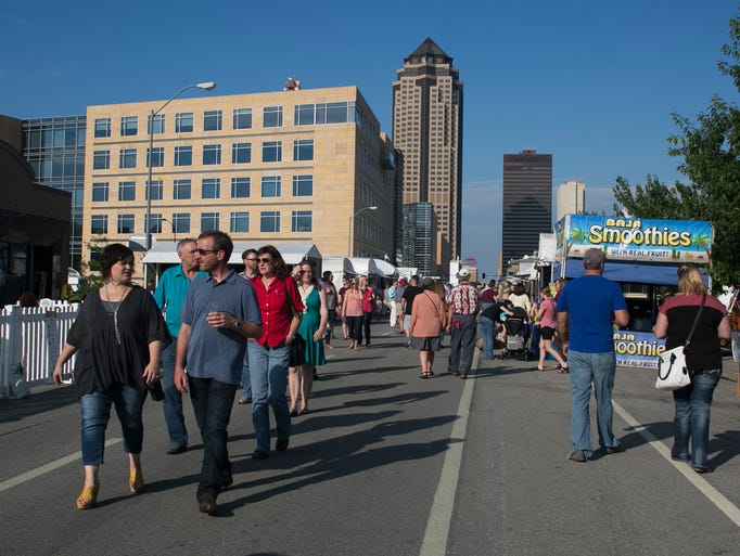A crowd walks down the street during the Des Moines