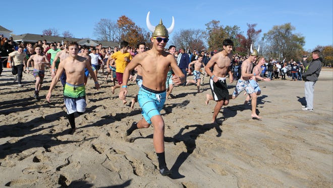 Participants race toward the water during the 8th annual "Freezin for a Reason" Polar Plunge fundraiser for Special Olympics at Glen Island Park in New Rochelle, Nov. 12, 2016. 