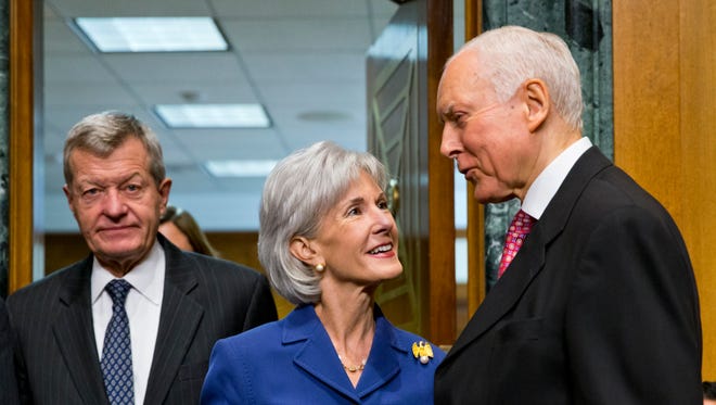HHS Secretary Kathleen Sebelius talks with Sens. Max Baucus and Orrin Hatch before testifying Wednesday.