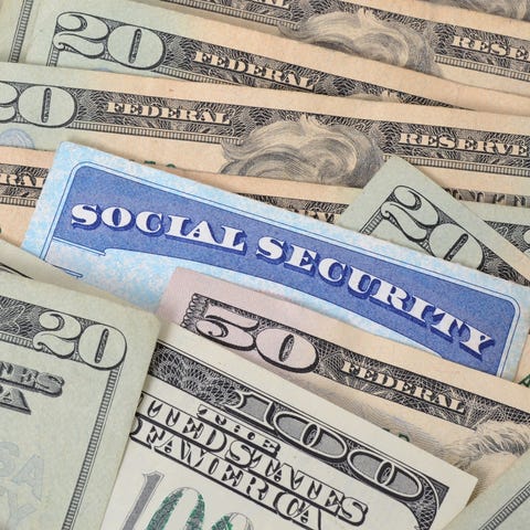 Social Security card embedded in spread-out money.