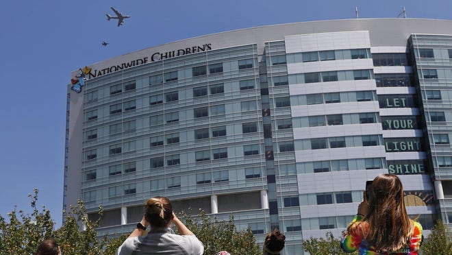 Health care workers at Nationwide Children's Hospital watch a flyover from the Ohio Air National Guard on May 13, 2020, to honor health care workers in the fight against COVID-19.