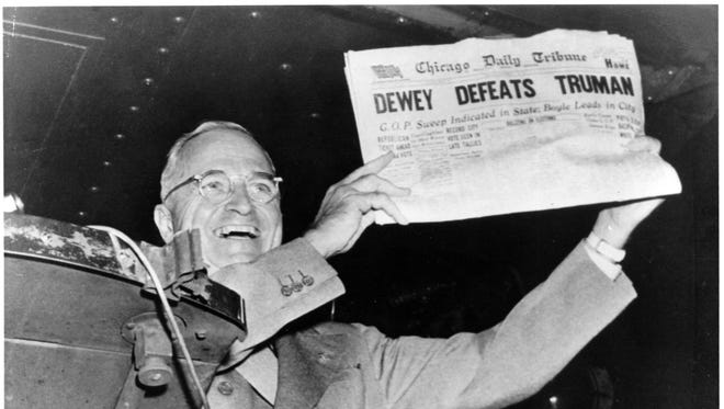 President Harry Truman holds up a copy of a Chicago Tribune newspaper, with an incorrect banner headline reading, "Dewey Defeats Truman," on Nov. 3, 1948.