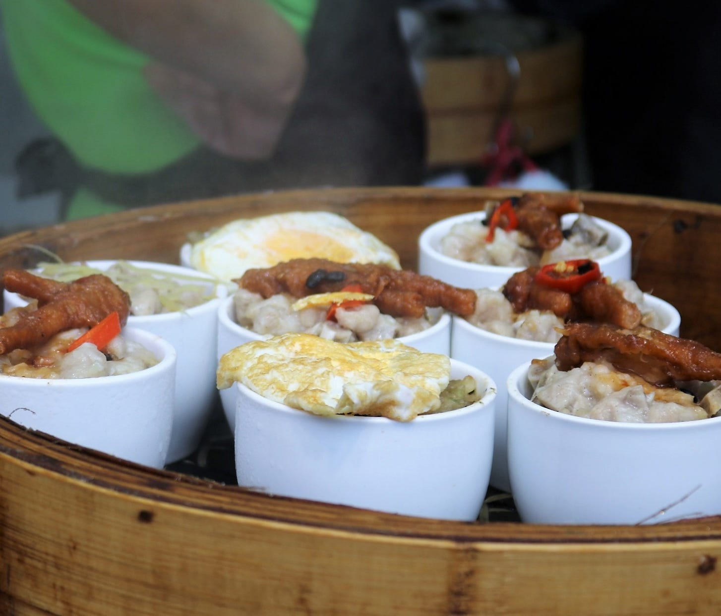 Small bowls from street stalls may be loaded with a variety of treats, such as dumplings, chicken feet, eggs or fried rice.