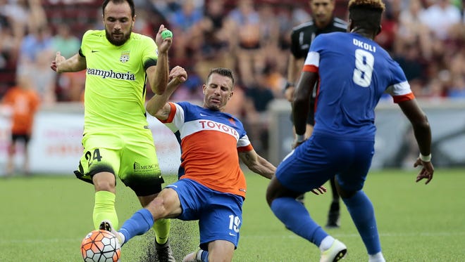 FC Cincinnati midfielder Corben Bone (19) slides for the ball in front of Charleston midfielder Zach Prince (24) during the first half of the USL soccer match between FC Cincinnati and the Charleston Battery at Nippert Stadium on the University of Cincinnati campus in Cincinnati on Saturday, July 30, 2016. At the half, the match was tied 0-0.