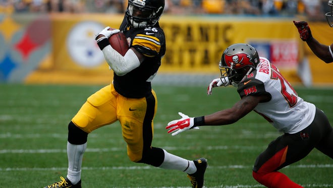 Pittsburgh Steelers running back Le'Veon Bell (26) runs past Tampa Bay Buccaneers cornerback Crezdon Butler (26) in the second quarter of the NFL football game on Sunday, Sept. 28, 2014 in Pittsburgh. (AP Photo/Gene J. Puskar)