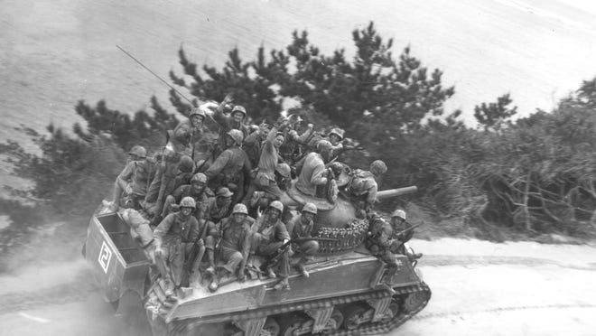 Sitting on a tank, U.S. infantrymen are seen on their way to take the town of Ghuta on Okinawa on April 1, 1945.