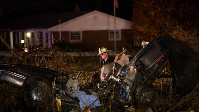 A firefighter inspects the scene where a man was killed in a fatal wreck on the Southeastside Tuesday, Dec. 1, 2015.