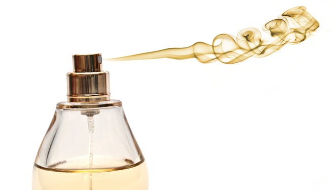 Photomanipulation of smoke and parfume bottle depicting spraying golden scent.