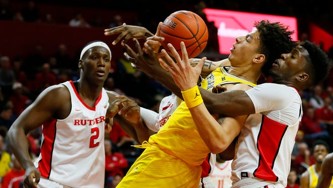 Feb 22, 2017; Piscataway, NJ, USA; Michigan Wolverines forward D.J. Wilson and Rutgers Scarlet Knights forward Jonathan Laurent battle for a rebound during the first half at Louis Brown Athletic Center.
