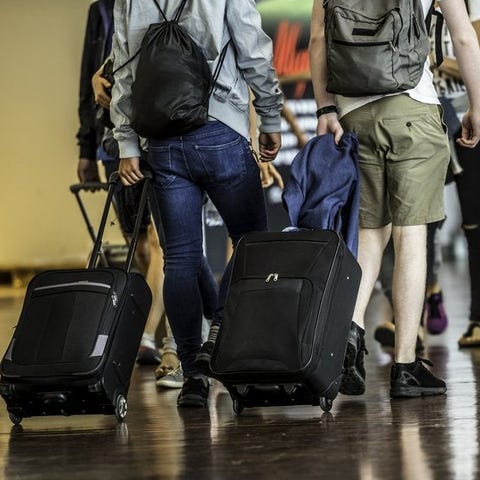 Travelers with suitcases walking through a crowded