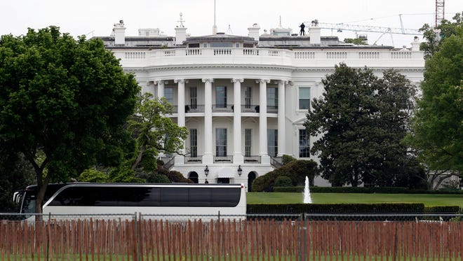 A bus carrying Senators drives inside the perimeter of the White House on Wednesday.