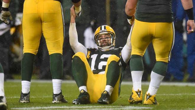 Green Bay Packers quarterback Aaron Rodgers (12) gets some help getting up from David Bakhtiari (69) and tackle JC Tretter (73) after failing to convert on fourth down against the Chicago Bears at Lambeau Field.