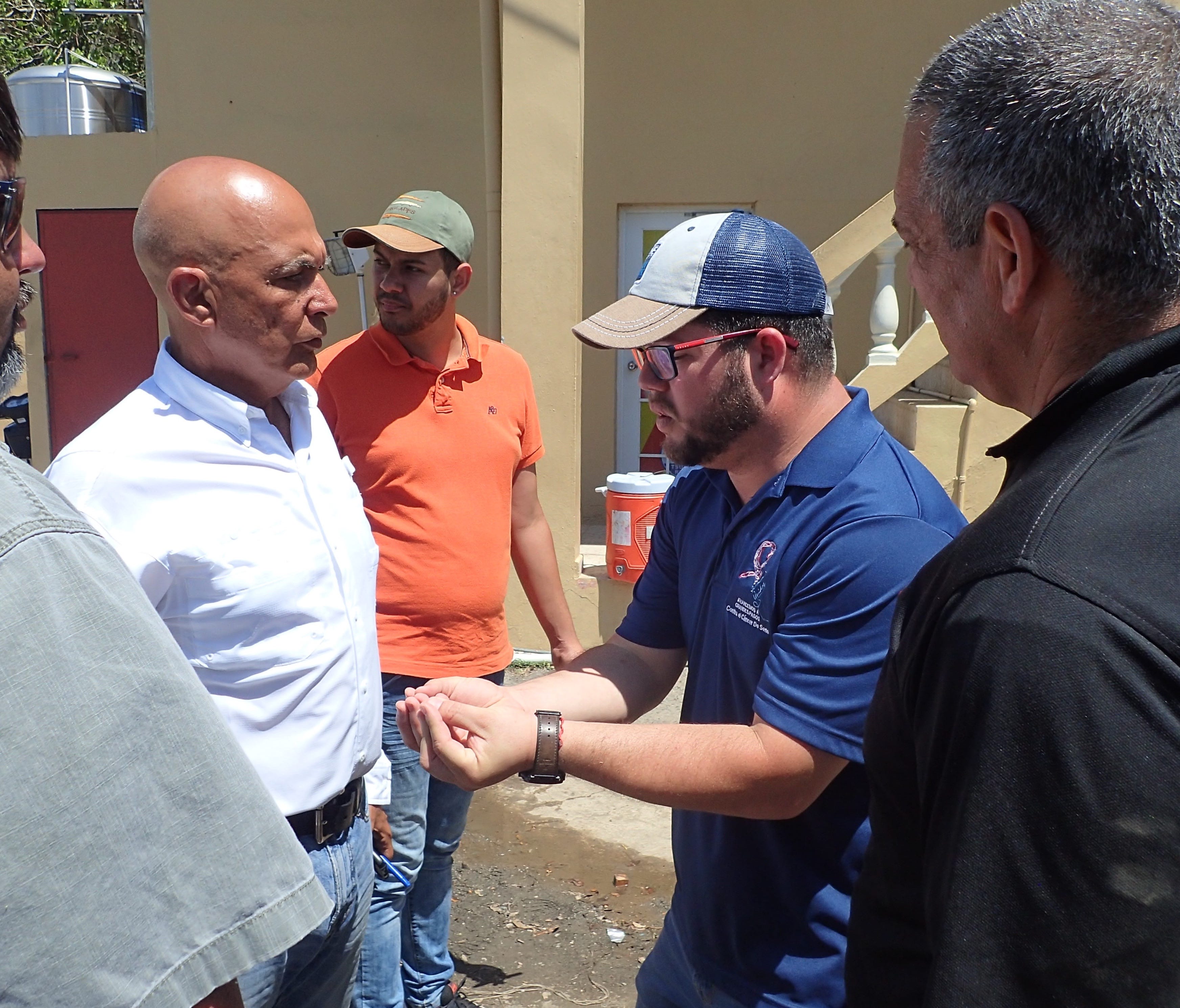 Guayanilla Mayor Nelson Torres, center in blue shirt, confers with staff on how to distribute water provided by FEMA through the Puerto Rico National Guard on Oct. 2, in Guayanilla.
